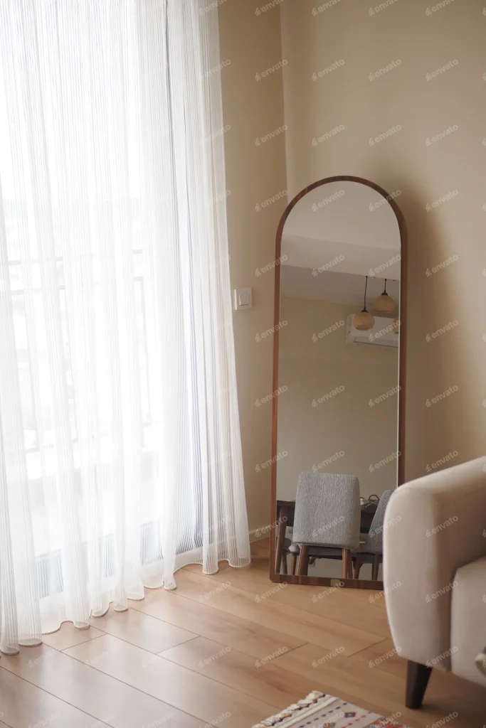 Sala com espelho arqueado e cortinas leves